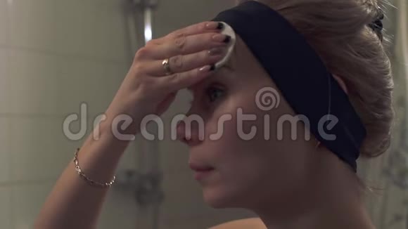 女孩在浴室里洗脸浴室里的年轻女子视频的预览图