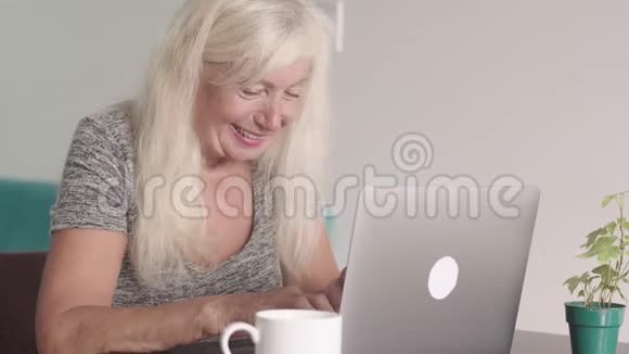 离退休老奶奶在家客厅用笔记本电脑特写镜头老年商业妇女视频的预览图