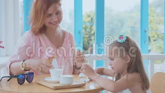 年轻的母亲和她的小女儿花时间在一家有冰淇淋的咖啡馆里视频的预览图