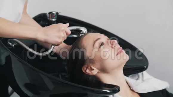 美发店里的年轻女子近距离洗头视频的预览图
