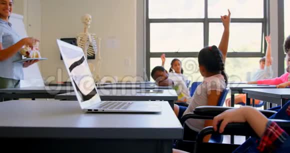 4k小学生在桌旁举手视频的预览图