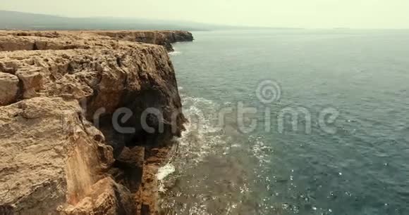 石海岸的大山背景相机向右移动石崖用蔚蓝色的水冲洗视频的预览图