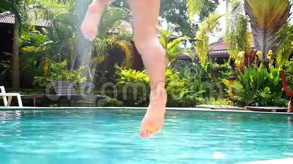 穿着黑色比基尼的年轻女子在热带岛屿茂盛的棕榈树丛林中跳进游泳池喜欢夏天的女孩视频的预览图