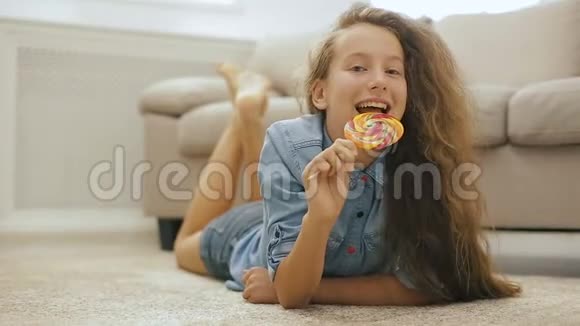 美丽的金发少女和糖果可爱的女孩和大甜棒棒糖视频的预览图