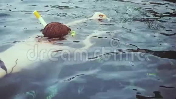 年轻的旅行者女人浮潜在面具里喂鱼在海里慢动作1920x1080视频的预览图