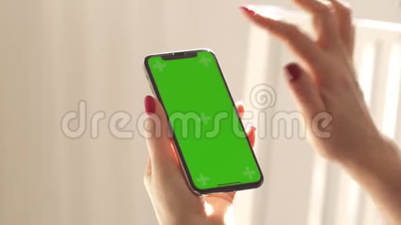 女性手握智能手机绿色屏幕赫罗莫基这个女人有一个红色的指甲视频的预览图