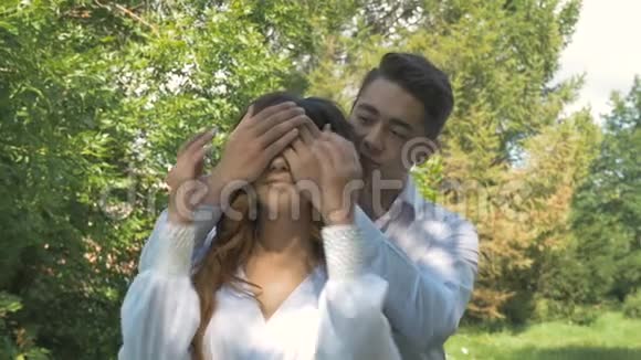 年轻漂亮的夫妇穿着白色衣服在公园里约会视频的预览图