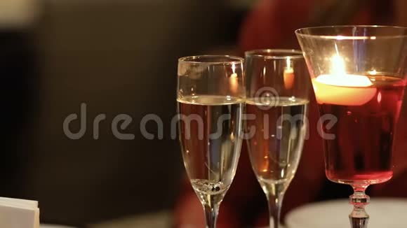 两杯香槟和一杯烧蜡烛的玻璃杯视频的预览图