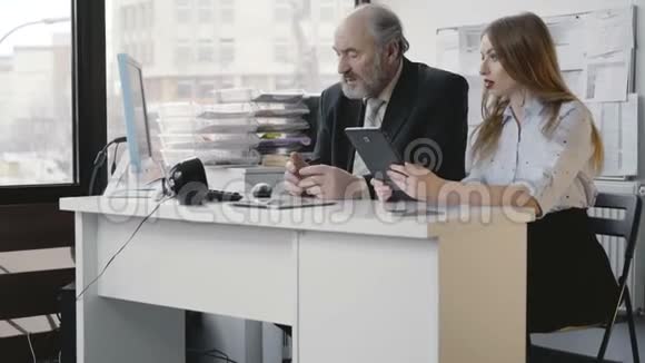 办公室女孩和她的老板在和平板电脑合作4K视频的预览图