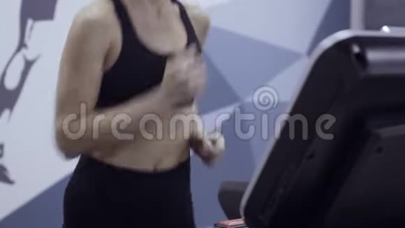 年轻运动的女人在健身房跑步机上跑步视频的预览图