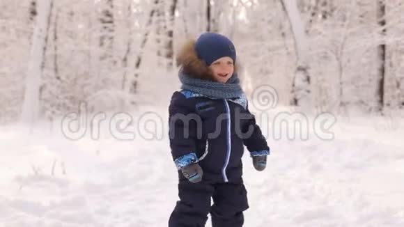 可爱的男孩在雪地公园跳舞和玩视频的预览图