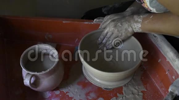 女人用粘土做陶瓷碗在陶器作坊工作视频的预览图