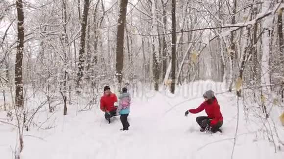 可爱的一家人在树林里的雪地里玩得很开心视频的预览图