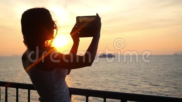 戴太阳镜的女孩在手机相机上拍摄日落的视频慢动作1920x1080视频的预览图