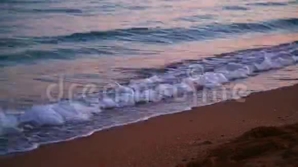 平静的傍晚海浪拍打在沙质海岸特写时光飞逝视频的预览图