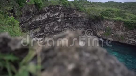 小沙滩在石拱前面的海洋破碎的海滩印度尼西亚努萨佩尼达视频的预览图