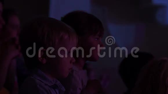 两个孩子在礼堂里看舞台视频的预览图