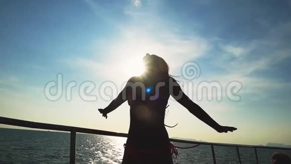 年轻苗条的比基尼女郎在游艇上摆姿势双手在阳光下举起镜头闪耀享受她的假期视频的预览图