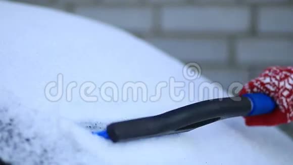 用刷子清除车上的积雪视频的预览图