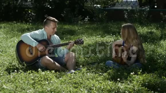 一个在公园里和一个女孩说话弹吉他的男人视频的预览图