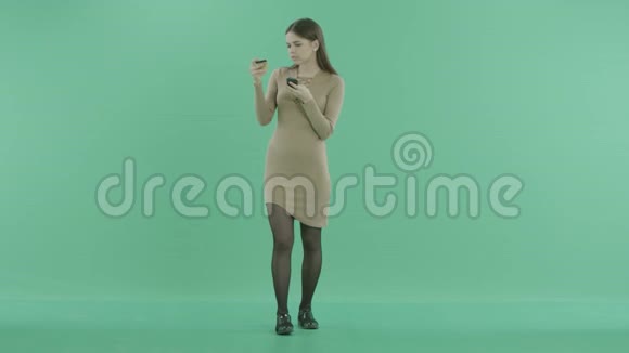 一个漂亮的女孩手里拿着一张塑料卡片和一个电话视频的预览图