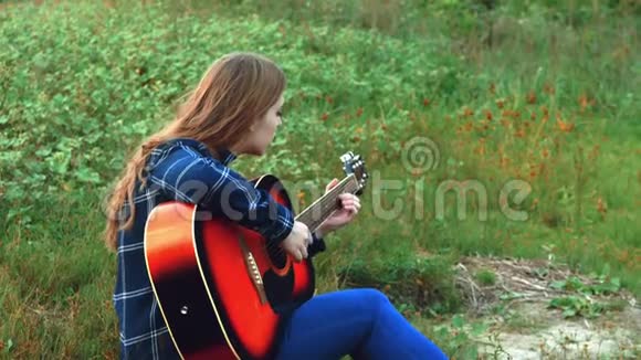 一个年轻的辛波蒂克纳亚女孩弹吉他当太阳越过地平线时她很孤独4k视频的预览图