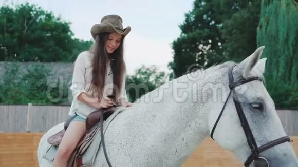 年轻快乐的女孩在这个地区摆着一匹漂亮的白马4K视频的预览图