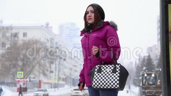 冬天一个女孩站在公共汽车站视频的预览图