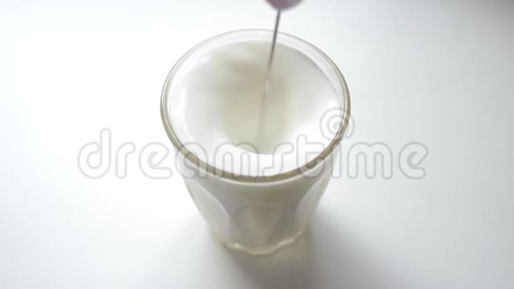 巴利斯塔用一只手奶泡在一个面玻璃烧杯中搅拌牛奶泡沫视频的预览图