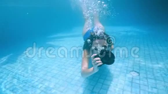 年轻女子潜入水中从水下看喷雾暑假概念跳到游泳池女孩视频的预览图