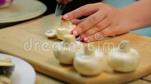 一个女人用一把刀在木板上把香瓜蘑菇切成薄片视频的预览图