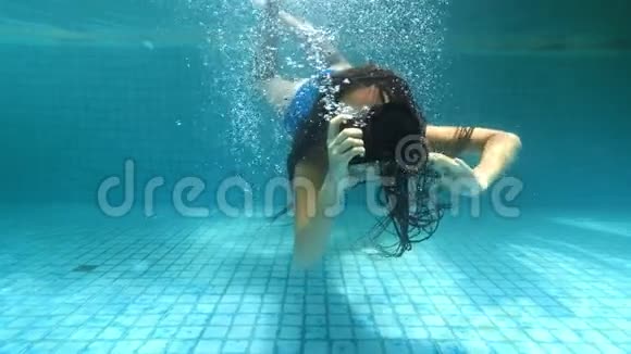 在亚洲旅行的女孩快乐的年轻女子一头美丽的长发在温泉池里拿着相机在水里游来游去视频的预览图