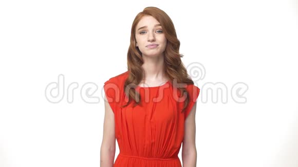 年轻美丽的白种人女子穿着华丽的橙色连衣裙站在白色背景下说不孤立视频的预览图