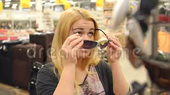 金发女孩在商店里试穿太阳镜视频的预览图