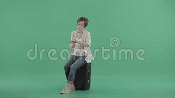 坐在手提箱上的漂亮孕妇视频的预览图