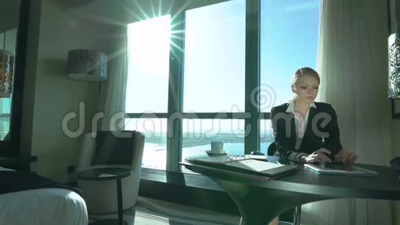 年轻的金发商务女性喝茶在办公室休息出差美丽的女士在椅子上旋转视频的预览图