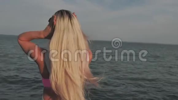 年轻女子把头发贴在海面上视频的预览图