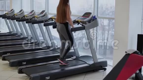 非常漂亮的女人在健身房的跑步机上锻炼视频的预览图