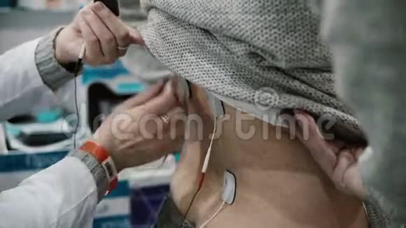 特写护士在患者背部安装设备对人体进行专业电疗视频的预览图