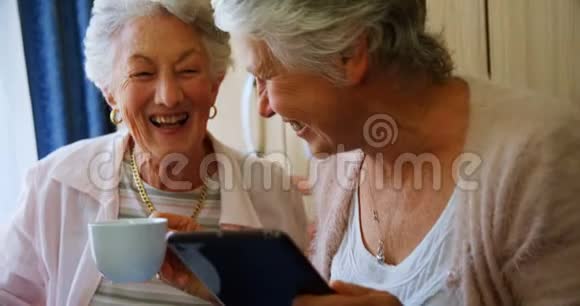 快乐的老年女性使用数码平板电脑4k视频的预览图