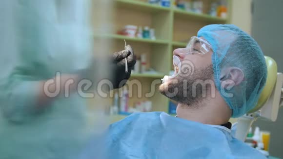 医生在牙科诊所用拉钩检查病人视频的预览图