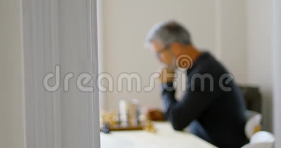 在客厅下棋时喝咖啡的男人视频的预览图