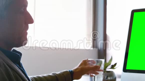 男性高管在台式电脑工作时饮用饮用水视频的预览图