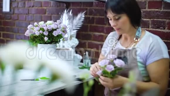 专业花店清洁和检查干花瓣上的白玫瑰枝视频的预览图