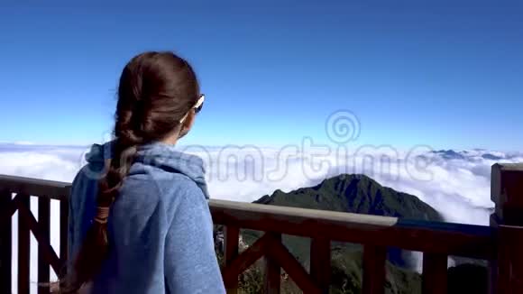 女游客举手在萨帕的范西潘山上看风景视频的预览图