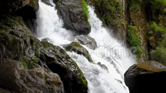 级联瀑布慢动作群山之间的水流巨大的巨石和倒下的树木干净清晰视频的预览图