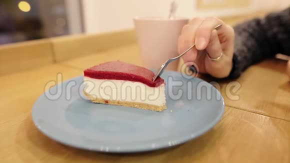 女孩吃了第一块美味的奶酪蛋糕晚上在咖啡馆里喝着芳香茶特写镜头视频的预览图