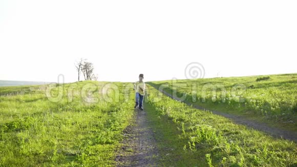 小男孩在草地上的乡间小路上奔跑视频的预览图