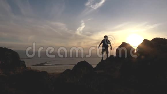 日落时分活跃的男孩在山上徒步旅行视频的预览图