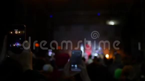 音乐会上的人们年轻人手中的智能手机拍摄音乐晚会的视频视频的预览图